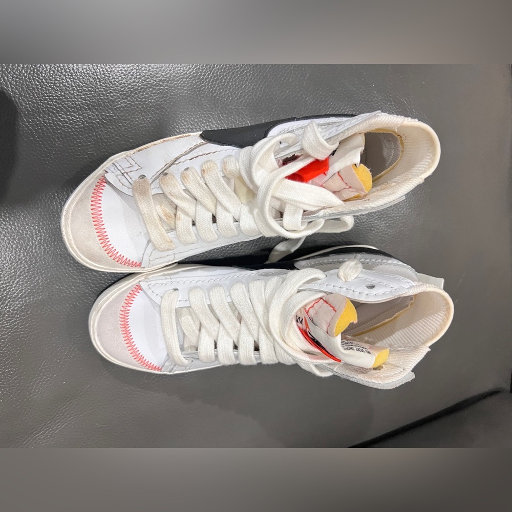 Nike White and Yellow Athletic Shoes high top . One sneaker has a dirty lace